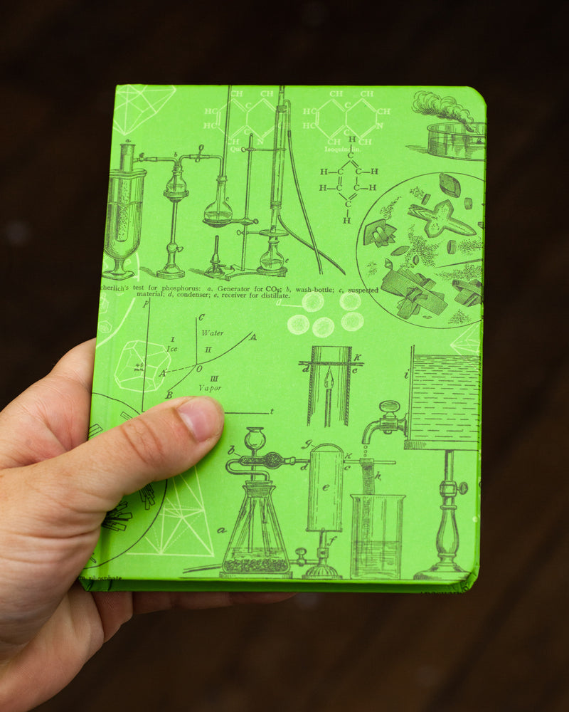 Chemistry beaker mini hardcover notebook by Cognitive Surplus, pictured in hand